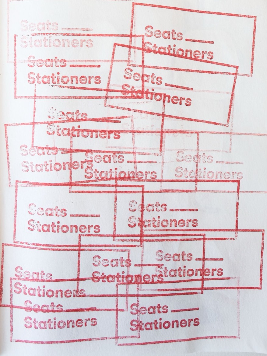 A sketchbook page covered in overlapping red rubber-stamp impressions reading Seats Stationers.
