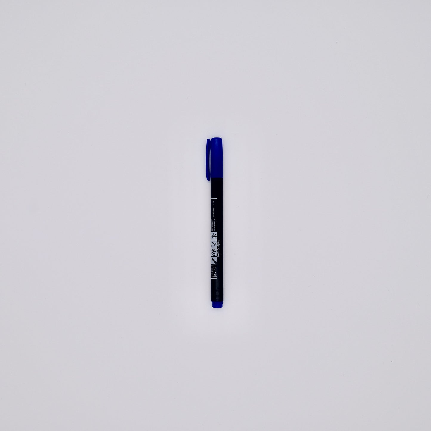 Black pen with blue cap on a white background