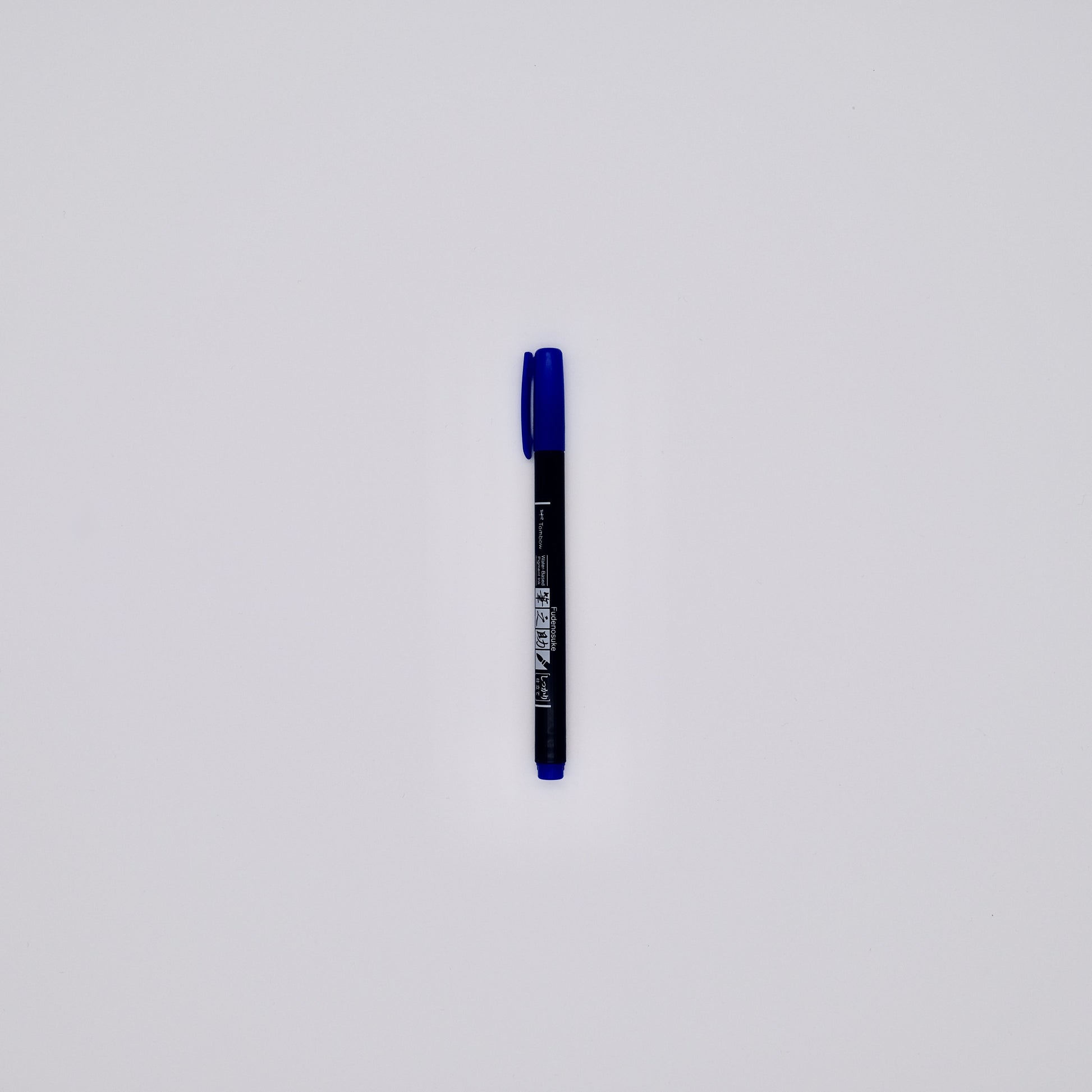 Black pen with blue cap on a white background