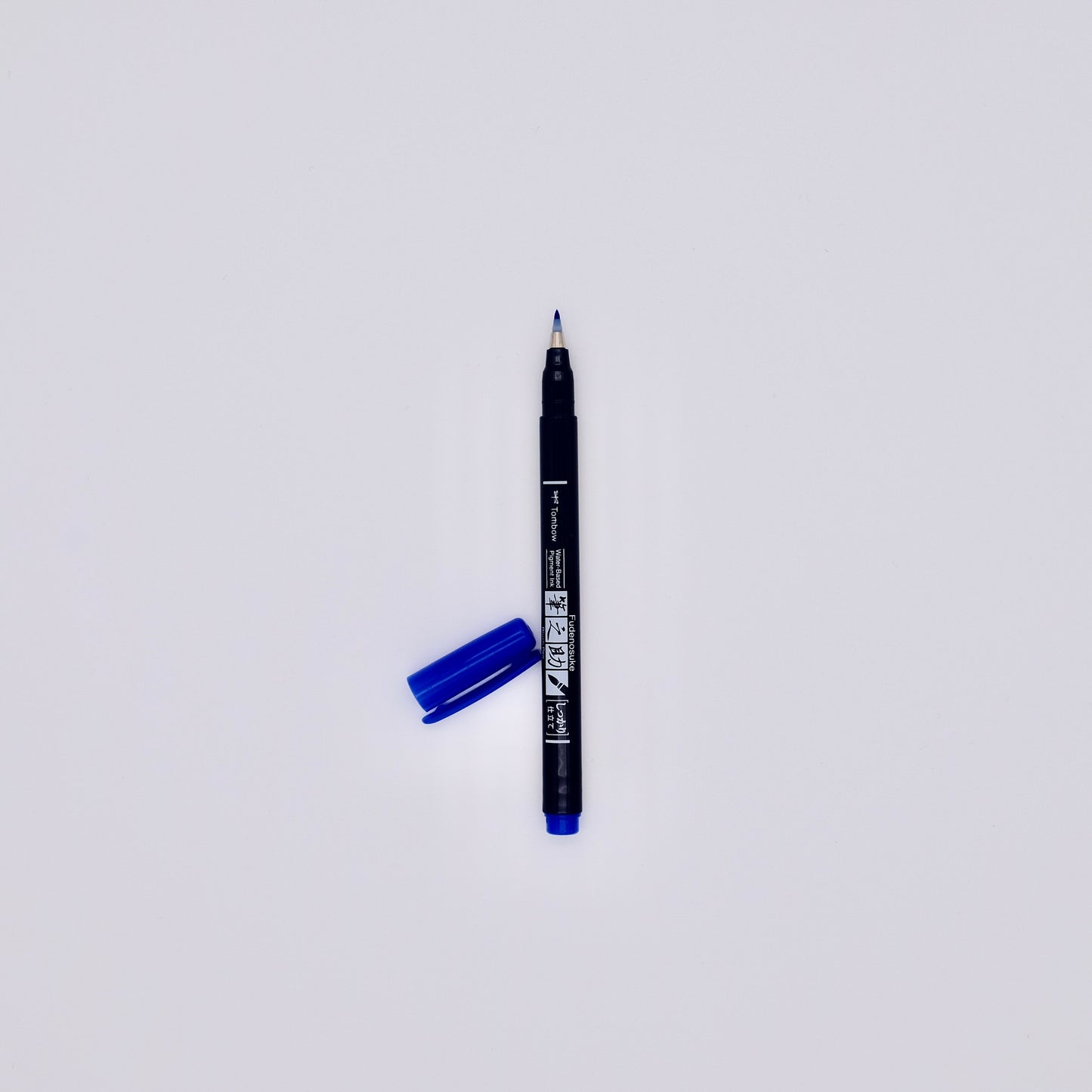 Black marker pen with blue cap on a white background