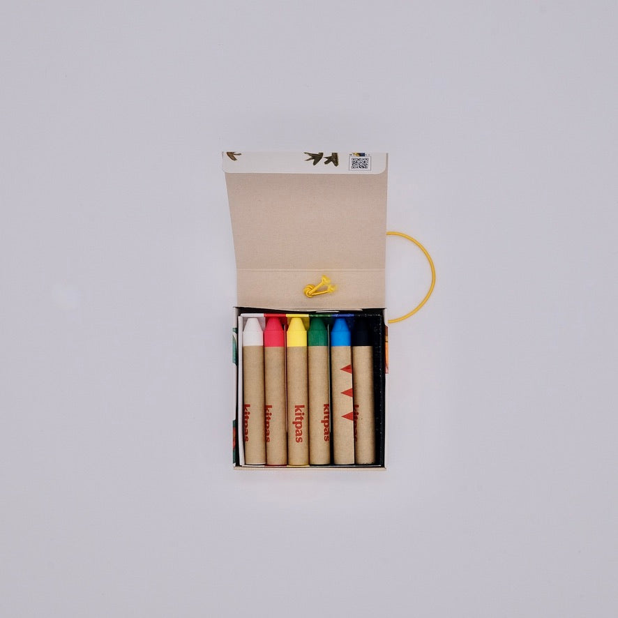 Set of colorful crayons in an open box on a light gray background