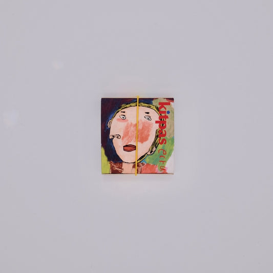 Small square box with a stylized face design on a light gray background