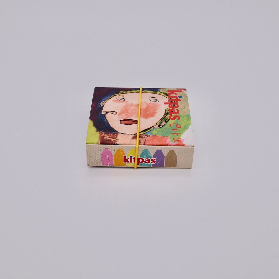 Colorful box with a face design and kitpas branding on a light gray background