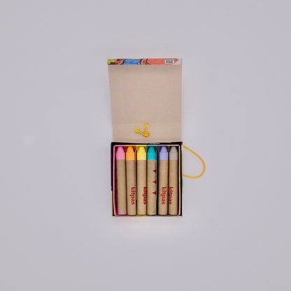 Set of colorful crayons in a box on a light gray background