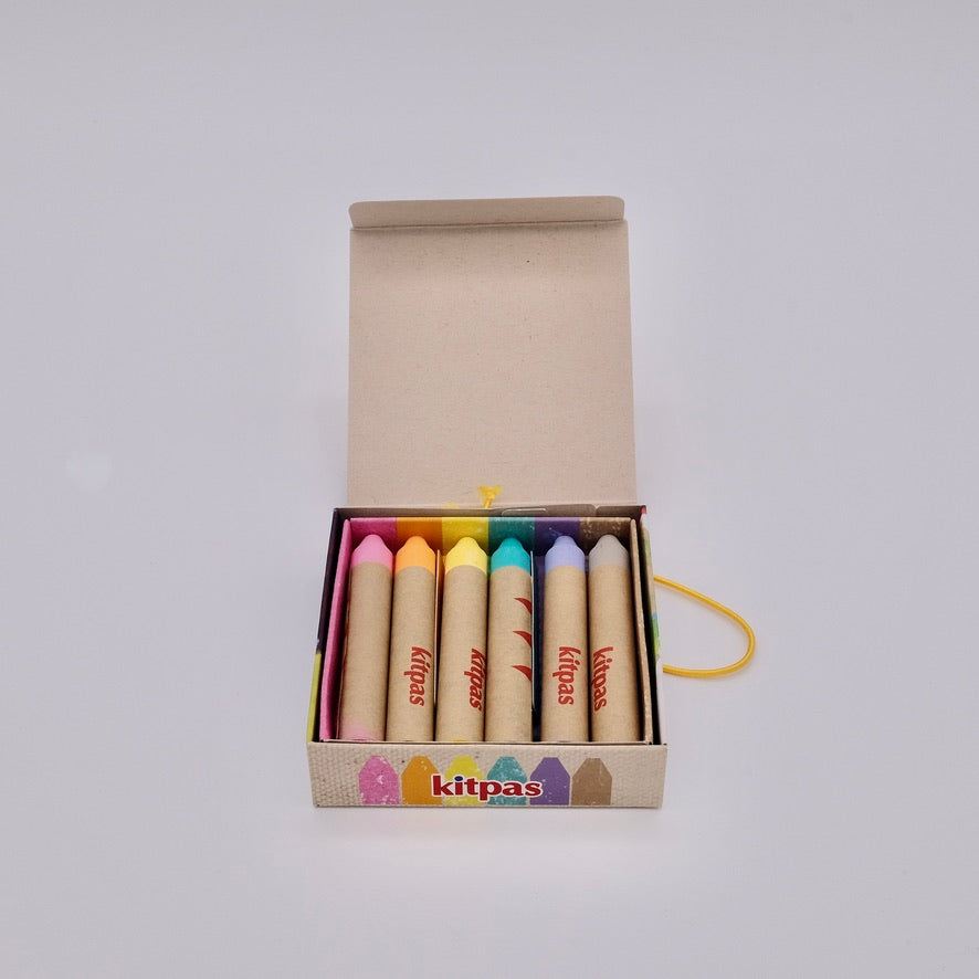 Set of colorful crayons in a box with 'kitpas' branding on a white background