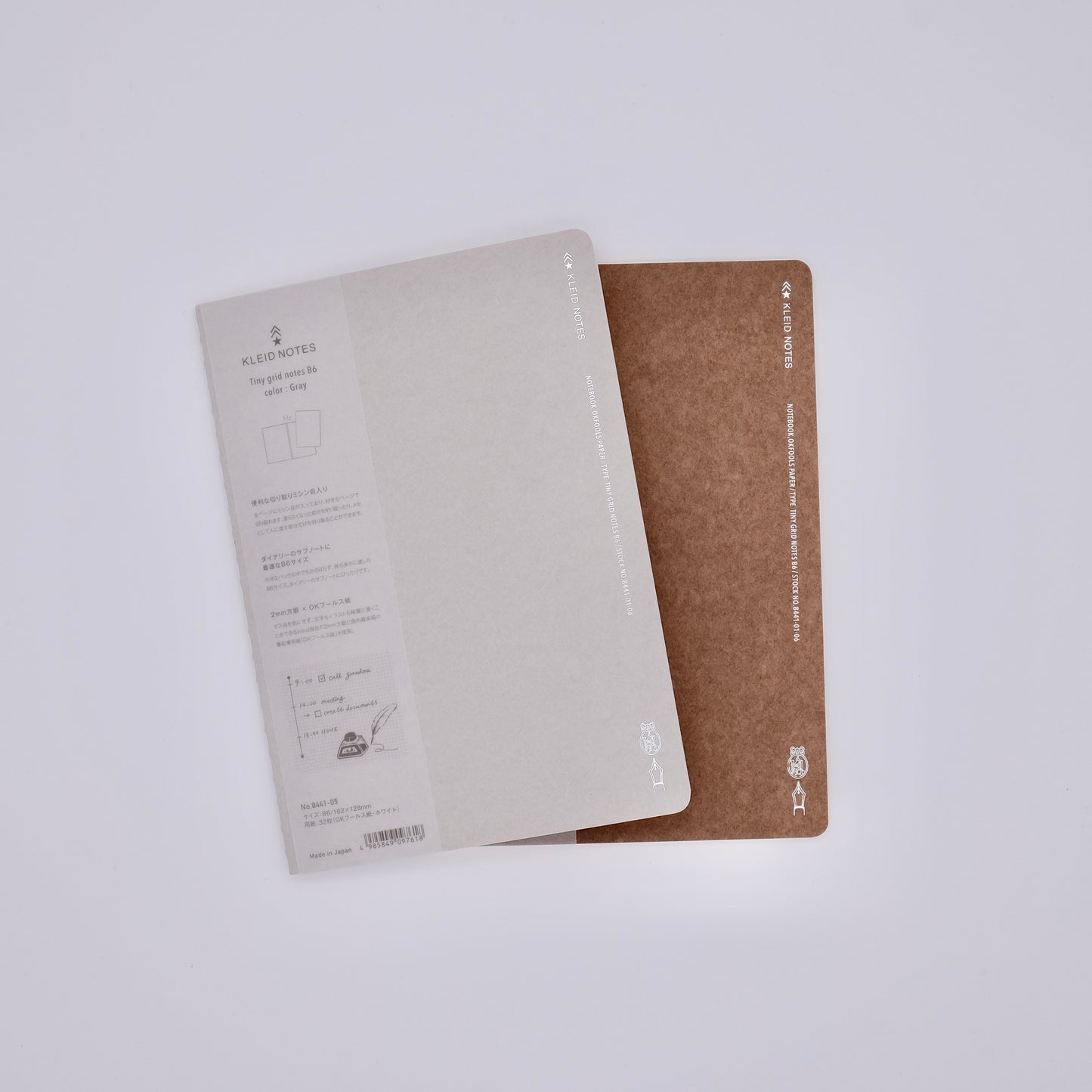 Two notebooks, one beige and one brown, on a white background