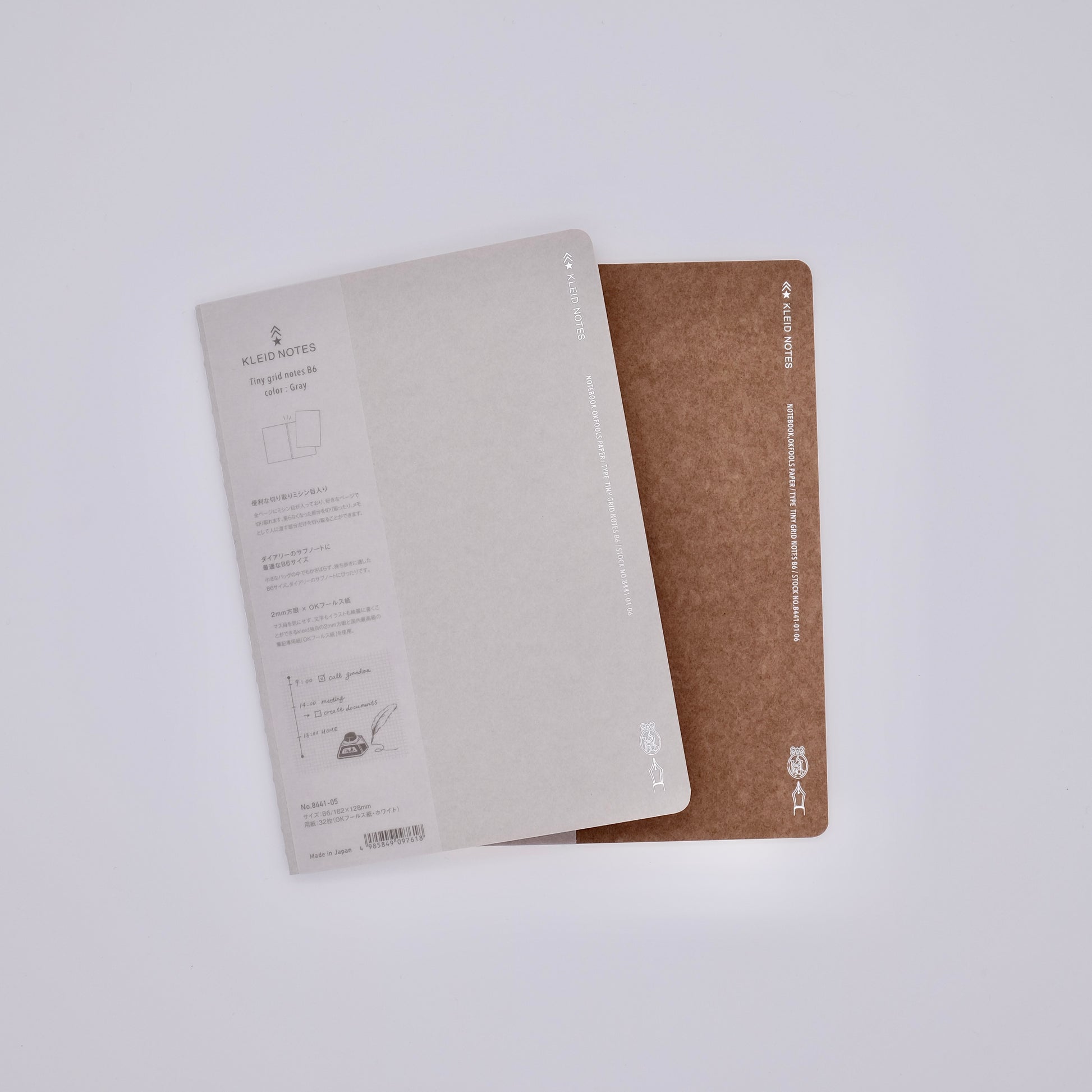Two notebooks, one beige and one brown, on a white background