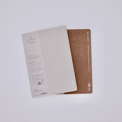 Two notebooks, one beige and one brown, on a white background