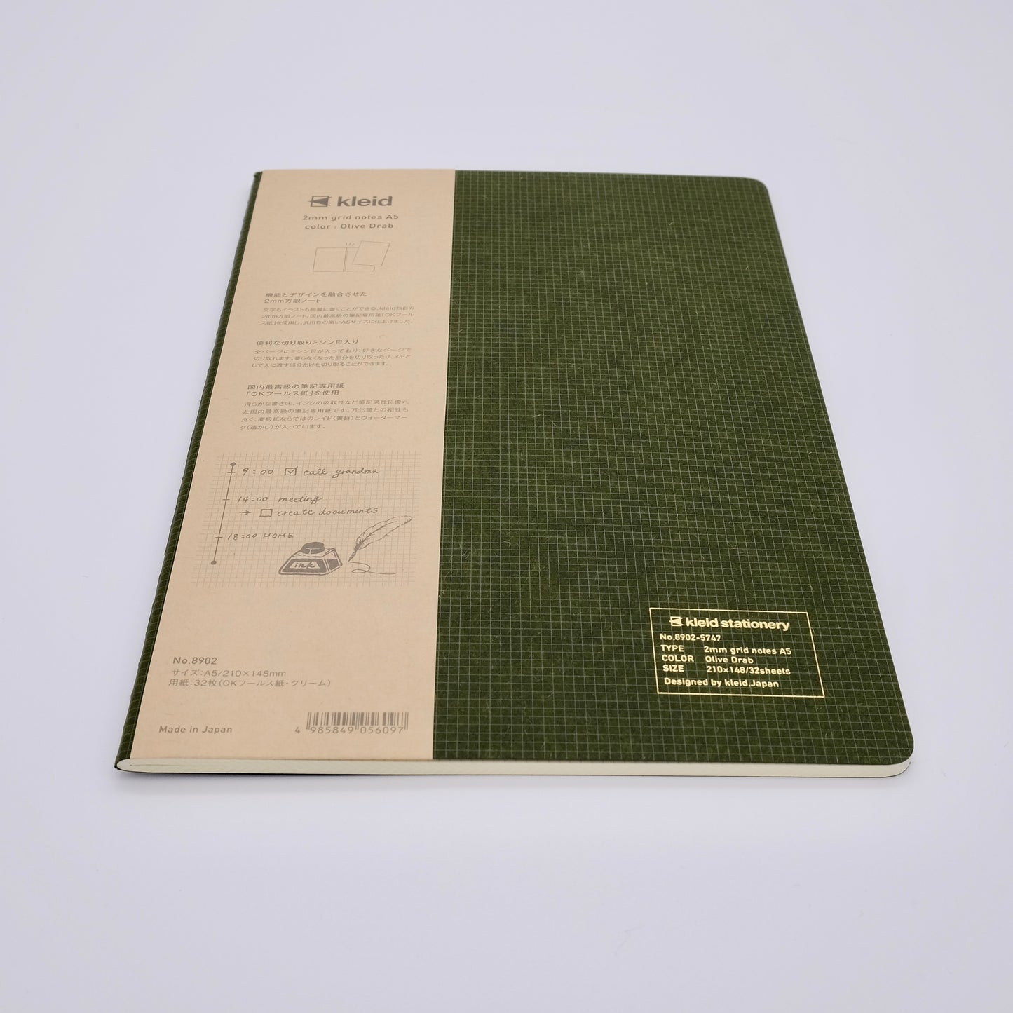 Green notebook with grid pattern on a white background