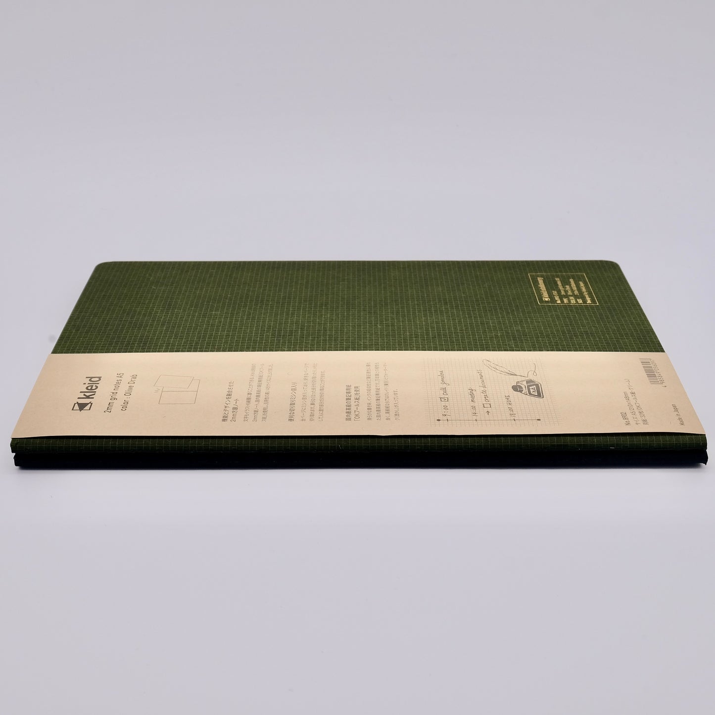 Green notebook with beige label on a light gray background