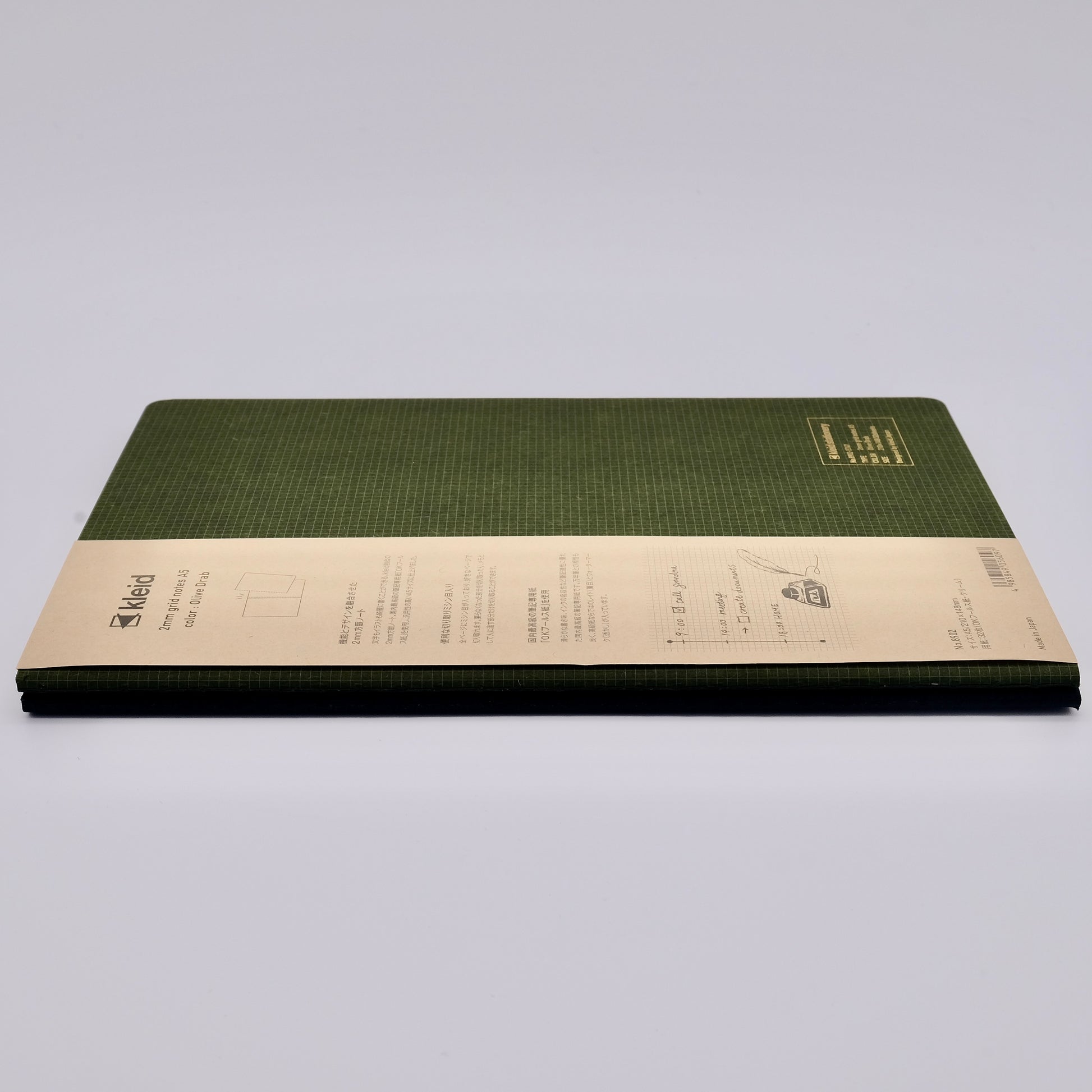 Green notebook with beige label on a light gray background