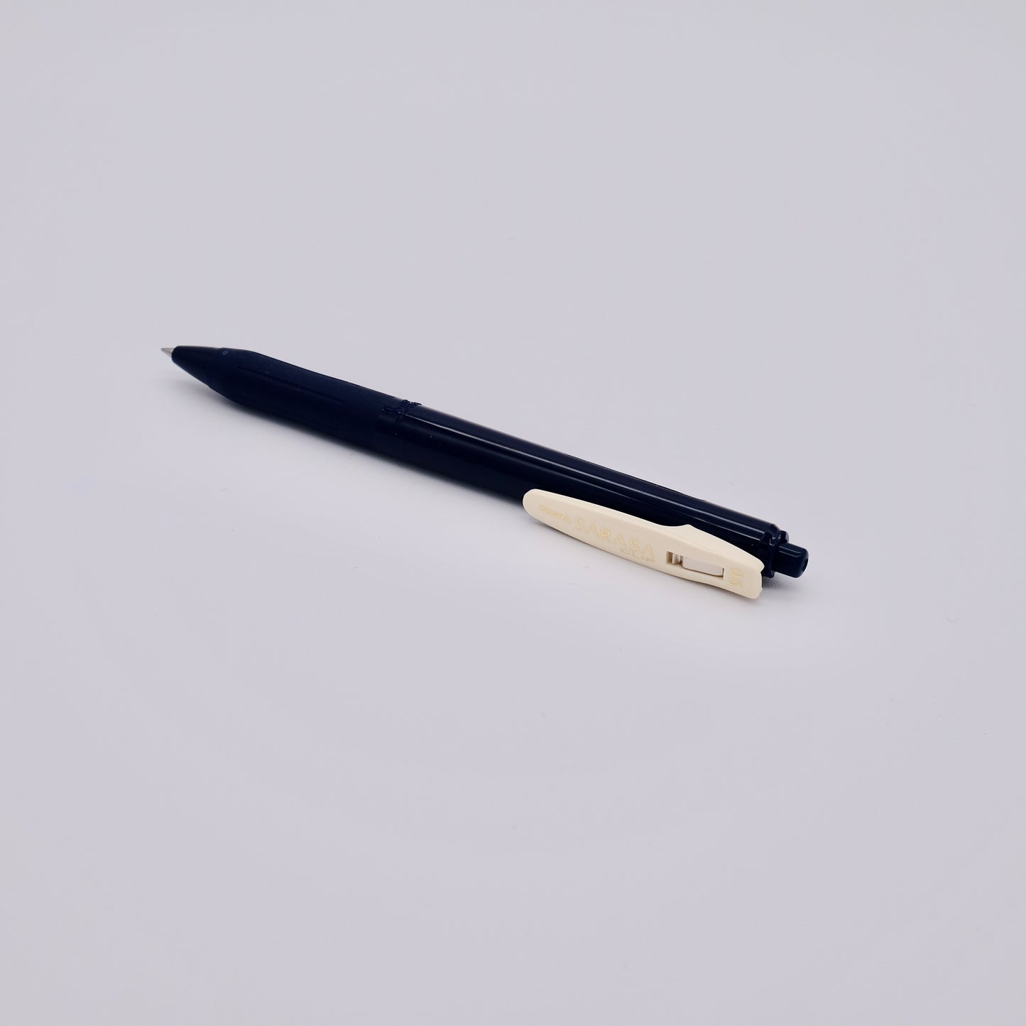 Dark blue pen with a beige clip on a light gray background
