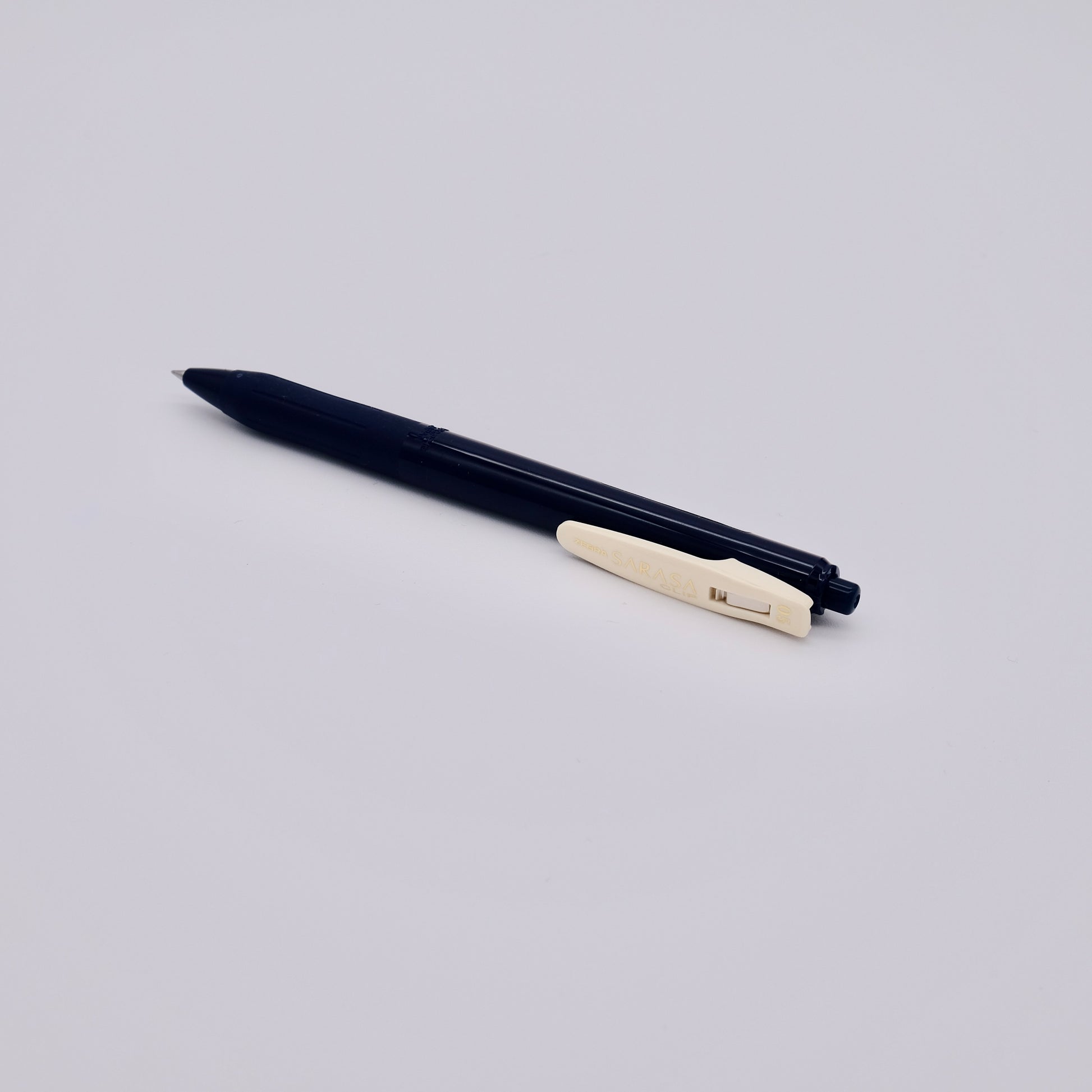 Dark blue pen with a beige clip on a light gray background