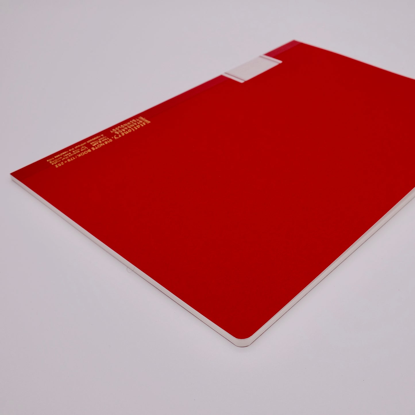Red notebook with a white label on a light gray background