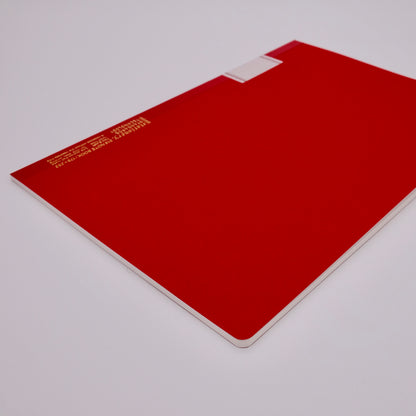 Red notebook with a white label on a light gray background