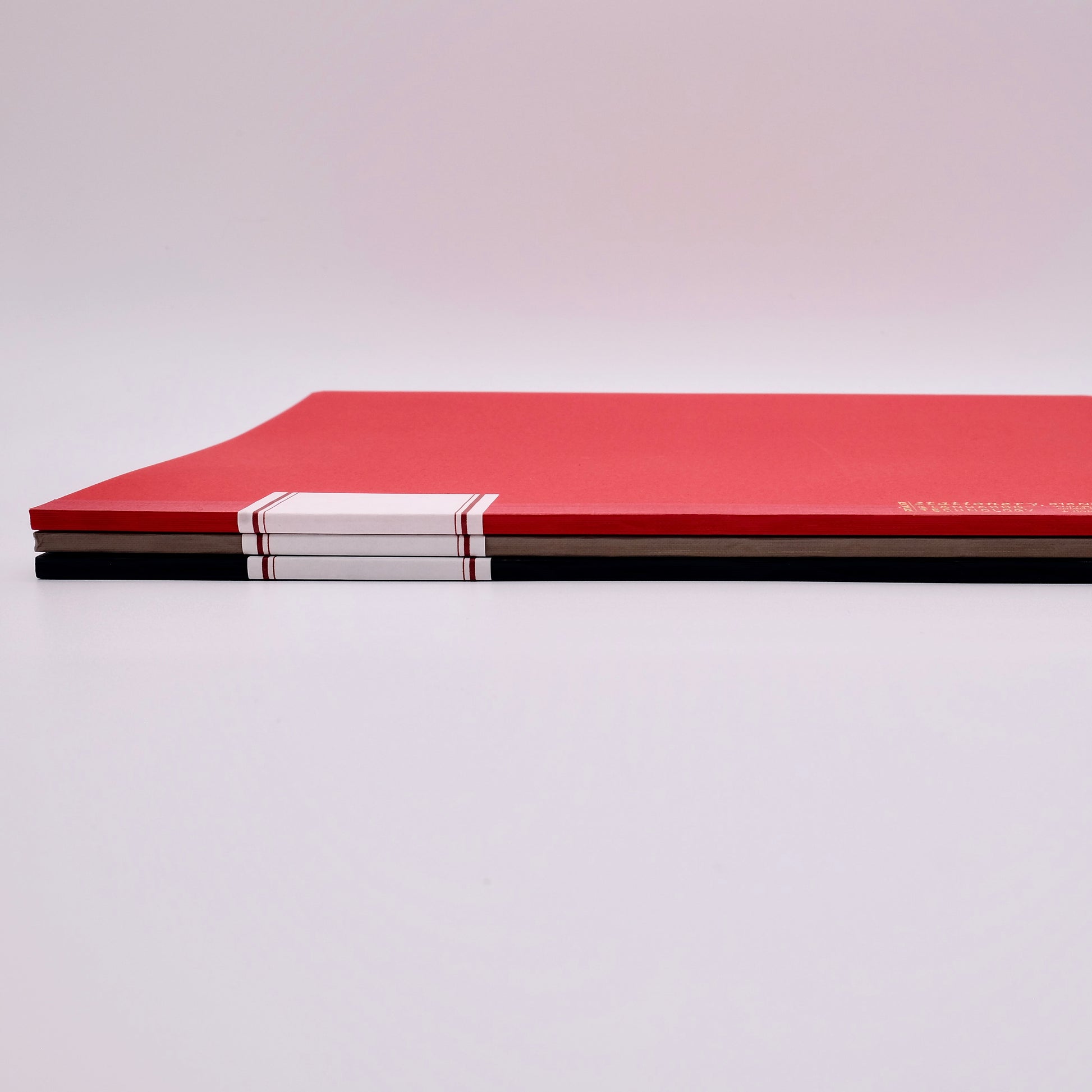 Red notebook with a white strip on a light gray background