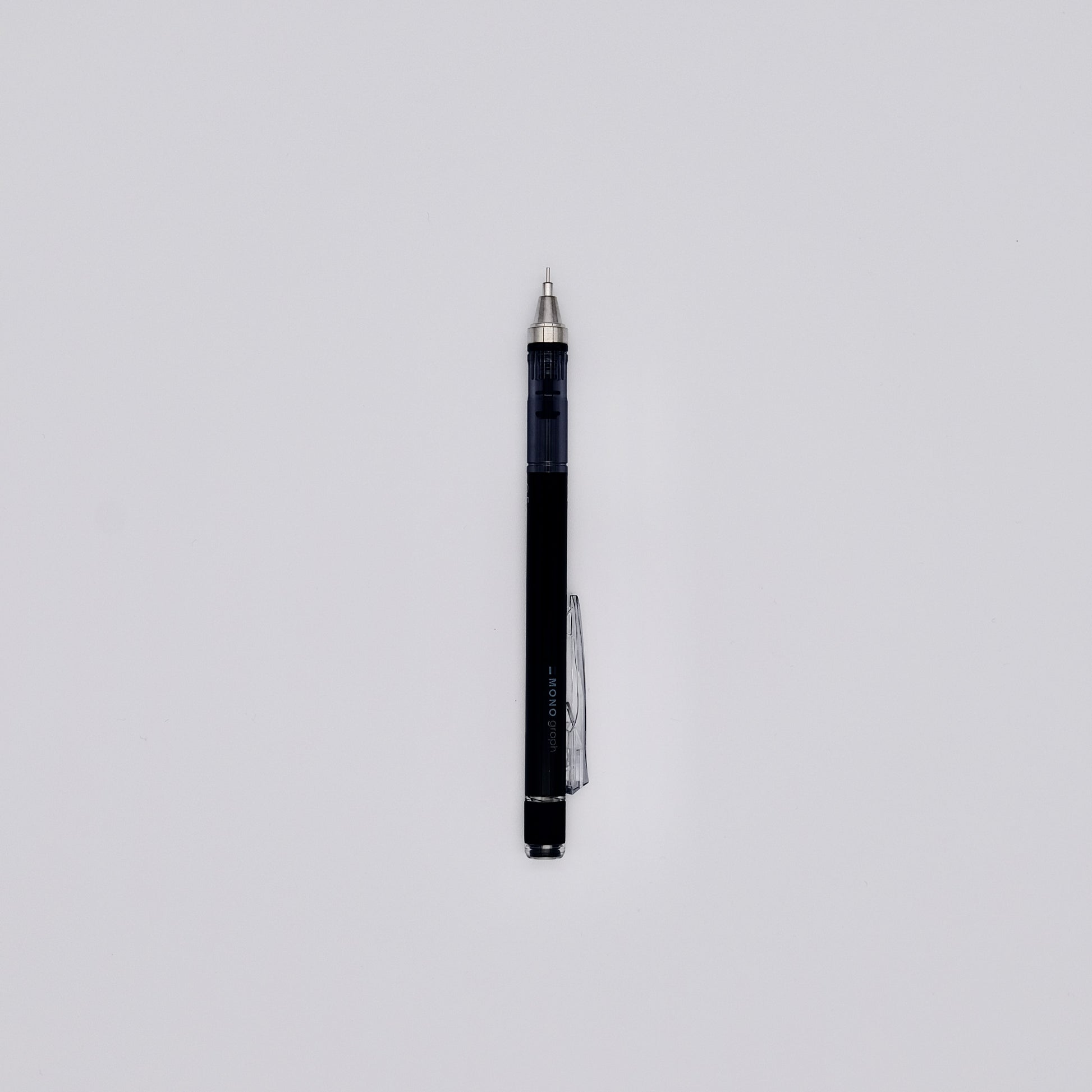 Black mechanical pencil with silver accents on a light gray background